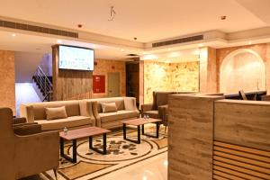 eine Hotellobby mit Sofas und einer Leinwand in der Unterkunft بيوت ملاذ للشقق الفندقية in Dschidda