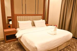 a hotel room with a bed with a doll on it at بيوت ملاذ للشقق الفندقية in Jeddah