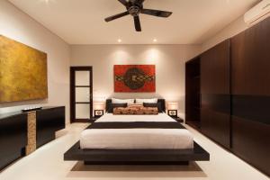 - une chambre avec un grand lit et un ventilateur de plafond dans l'établissement Amalika Private Pool Villa Central to Everything, à Gili Trawangan
