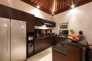 a kitchen with a refrigerator and a bowl of fruit on a counter at Amalika Private Pool Villa Central to Everything in Gili Trawangan