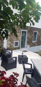 un patio con sedie, tavoli e un albero di Casa do Monte a Faial da Terra
