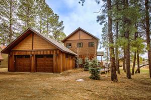 a wooden house with a garage in the woods at Casa Panchoy in Pagosa Springs