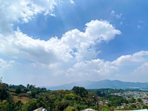 Un ciel bleu avec des nuages et une ville dans l'établissement El Jardín de Banu, à Magdalena Milpas Altas