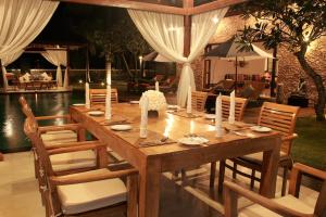 a wooden table with chairs and a dining room at Villa The Jiwa in Tanjung
