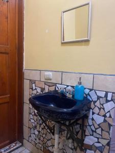 La salle de bains est pourvue d'un lavabo bleu et d'un miroir. dans l'établissement El Jardín de Banu, à Magdalena Milpas Altas