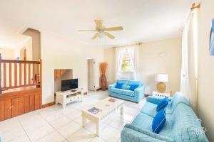 a living room with a blue couch and a tv at 2-Story Townhome with Private Pool, Ideal for Group! in Christ Church