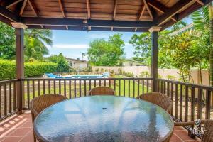 a glass table and chairs on a balcony with a pool at 2-Story Townhome with Private Pool, Ideal for Group! in Christ Church