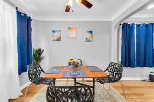 - une table et des chaises dans une chambre dotée de rideaux bleus dans l'établissement Renovated Brooklyn Townhome 9 Miles from Downtown, à Brooklyn