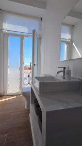 a bathroom with a sink and a toilet and a mirror at Come Inn Sintra in Sintra