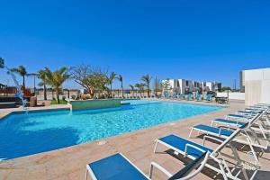 a swimming pool with lounge chairs and a swimming pool at New Townhome Private Patio Parking Pool Onsite in La Paz