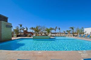 a large blue swimming pool with palm trees in the background at Stylish Townhome with Pool, Patio, and Secure Parking in La Paz