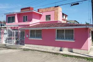 ein rosa Haus mit einem Tor davor in der Unterkunft King Size, jacuzzi, Dream House: oasis of peace in Coatepec