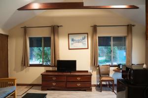 sala de estar con TV y 2 ventanas en Dean Creek Resort, en Redway