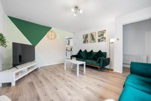 a living room with a green couch and a tv at Monthly Rates Cosy 3 Bed Free Parking -Contractors Families in Solihull