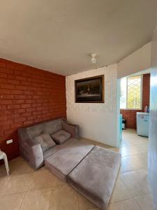 a living room with a couch and a brick wall at La Orquidea Airbnb in Piñas