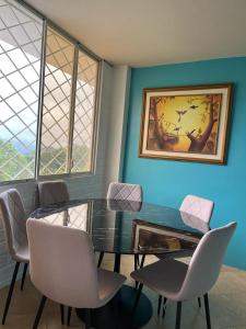 a dining room with a glass table and chairs at La Orquidea Airbnb in Piñas
