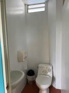 a small bathroom with a toilet and a sink at La Orquidea Airbnb in Piñas
