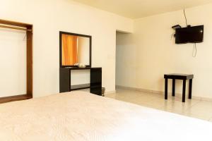 1 dormitorio con cama, espejo y TV en HOTEL KRISTAL, en Asunción Nochixtlán