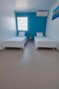 a hospital room with two beds and a blue wall at Villa Aléo in Sainte-Anne +26 photos