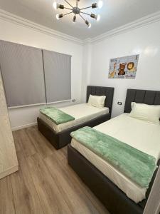um quarto com duas camas e um tecto em A very luxurious hotel apartment in Obour, the entertainment district, second floor, without an elevator em ‘Ezbet el-Insha
