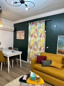 uma sala de estar com um sofá e uma mesa em A very luxurious hotel apartment in Obour, the entertainment district, second floor, without an elevator em ‘Ezbet el-Insha