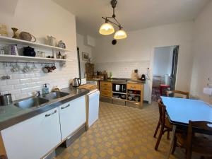 una cocina con fregadero y mesa. en Nouveau - La Maison du Chemin vert en Dieppe