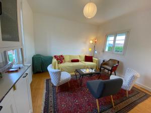 sala de estar con sofá, mesa y sillas en Nouveau - La Maison du Chemin vert en Dieppe