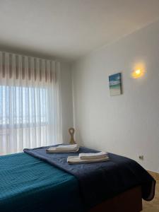 a bedroom with a blue bed with towels on it at Apartamento 806 in Albufeira