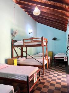 a room with four bunk beds and a checkered floor at ViaVia Leon in León +85 photos