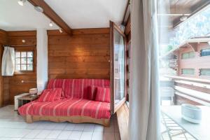 シャモニー・モンブランにあるMontets furnished flatのベッドルーム1室(赤いソファ付)