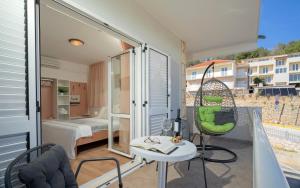 a room with a balcony with a table and a bed at Guesthouse Longin in Hvar