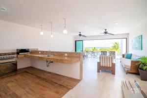 uma cozinha com um balcão e uma sala de estar em Beachfront Villas with Private Pool Steps to the Sea! em Chicxulub