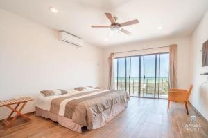 um quarto com uma cama e uma grande janela em Beachfront Villas with Private Pool Steps to the Sea! em Chicxulub