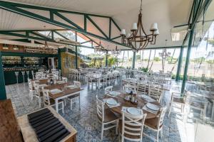 a restaurant with wooden tables and white chairs at Casa aconchegante perto do Clube Marina in Palmeiras