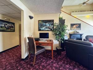 Zimmer mit einem Schreibtisch, einem Computer und einem Sofa in der Unterkunft Stay Wise Inn Cedaredge in Cedaredge