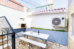 een balkon met een witte tafel en verwarming bij HU2i - In&Out Carcavelos in Carcavelos