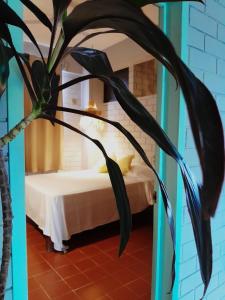 um quarto com uma cama e uma planta em HOTEL WAYAK em Palenque
