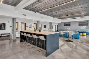 a large room with a bar with stools and tables at The Well #303 in Zephyrhills