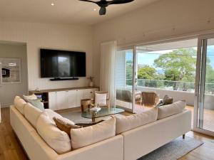 McCraeShelby Beachhouse - Scandi Hot Tub & McCrae Views的客厅里有一张白色沙发和一台电视