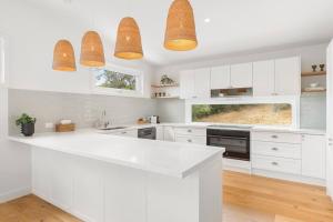 McCraeShelby Beachhouse - Scandi Hot Tub & McCrae Views的厨房配有白色橱柜和白色台面