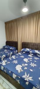 two beds in a bedroom with a blue comforter at Sweethome Mummy@Youthcity Nilai in Nilai