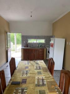 Il comprend une cuisine équipée d'une table et d'un réfrigérateur blanc. dans l'établissement Casa en La Puntilla, à Belén