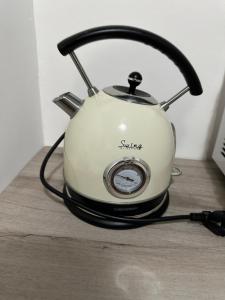 Una tetera colocada encima de una mesa de madera en Dora’s Stay, en Turín