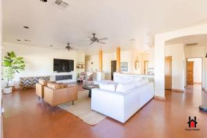 uma sala de estar com um sofá branco e uma televisão em Grand Desert Getaway with Pool and Peloton with Sonos and Office em Rio Verde