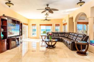 ein Wohnzimmer mit einem Ledersofa und einem TV in der Unterkunft Breathtaking Chalk Sound Private Pool Sunset Villa in Providenciales