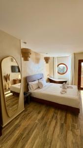 een slaapkamer met een groot bed en een spiegel bij Almas Pyramids Hotel in Caïro