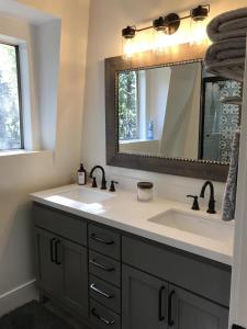 a bathroom with a sink and a mirror at Whispering Pine Modern Luxe 3 Level 2000 sqft AC View Dogs Village in Lake Arrowhead