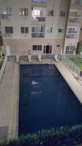 a large swimming pool in front of a building at Egidios AP - Centro de São Pedro da Aldeia in São Pedro da Aldeia
