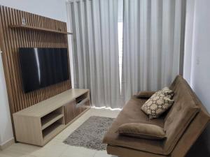 a living room with a couch and a flat screen tv at Egidios AP - Centro de São Pedro da Aldeia in São Pedro da Aldeia