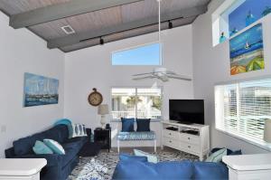 un salon avec un canapé bleu et une télévision dans l'établissement Ocean View Beach House Historic Downtown 10 mins, à Saint Augustine